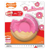 Pink donut-shaped toy with Nylabone branding on a colorful packaging background.